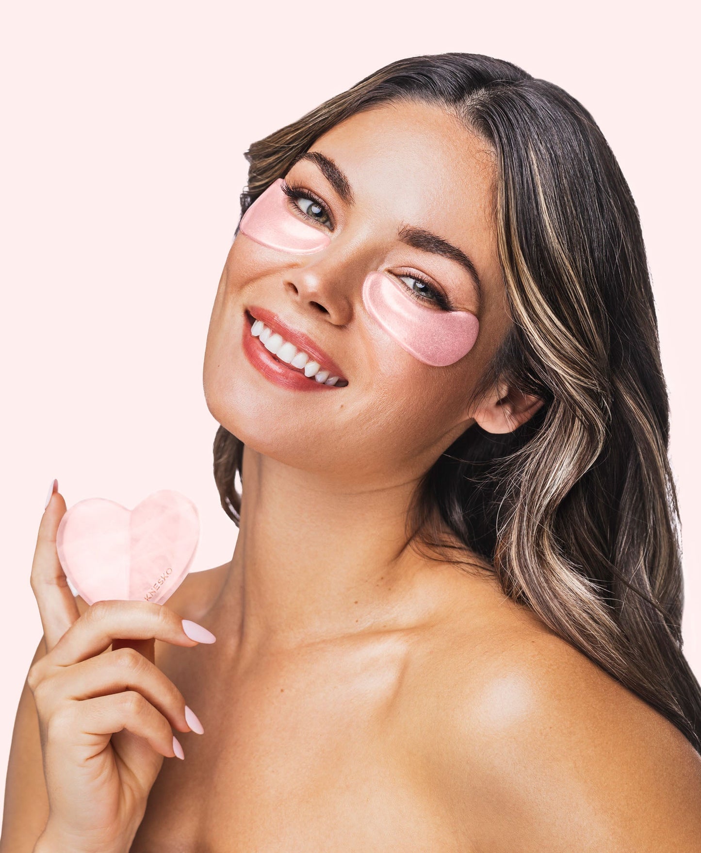 A woman using a Rose Quartz Gua Sha.