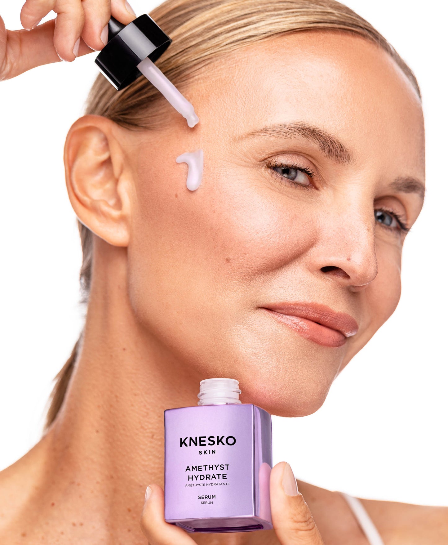 woman using amethyst hydrate serum on face