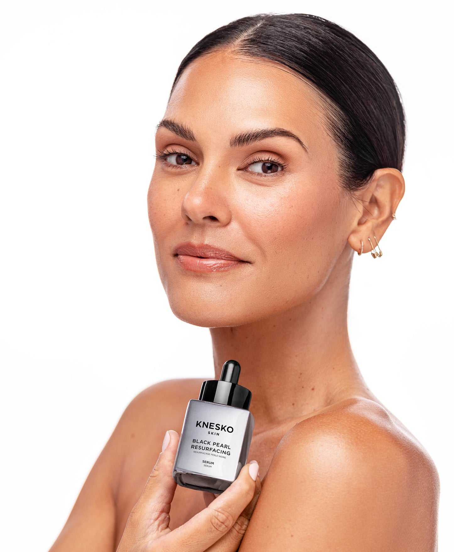 A woman using Black Pearl Resurfacing Serum.