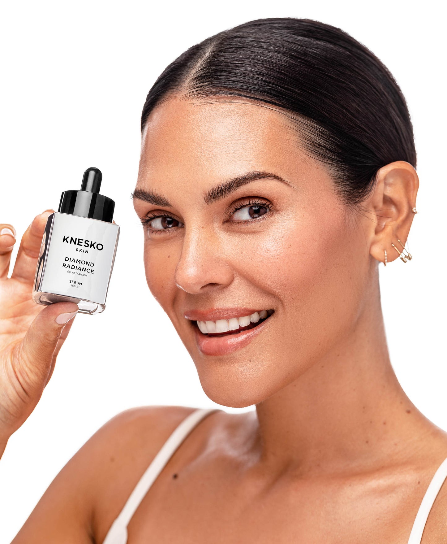 A woman using Diamond Radiance Serum.