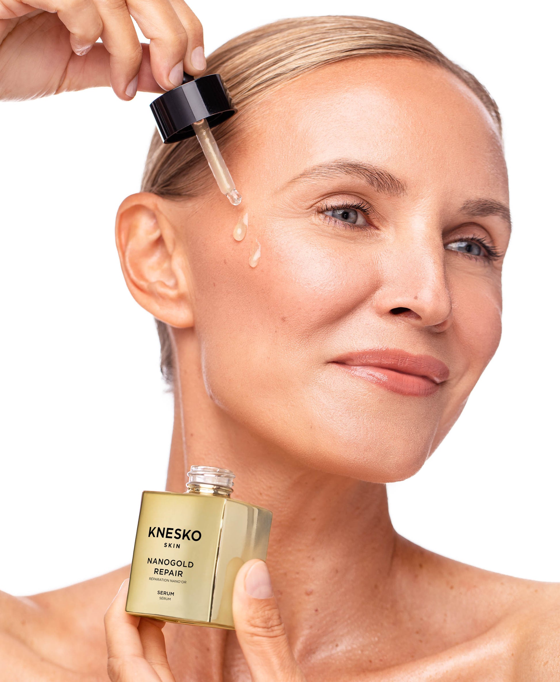 A woman using Nanogold Repair Serum.